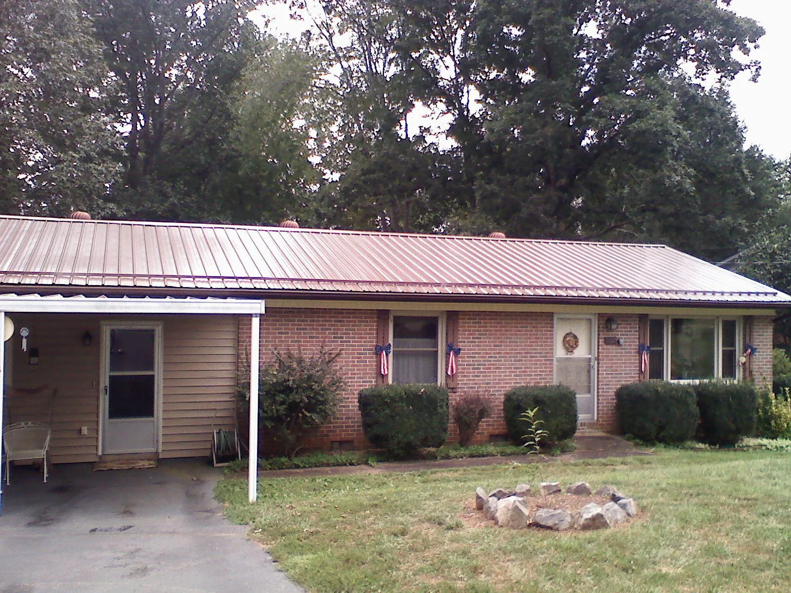 Bronze metal roof and carport on a brick ranch home — Roof Repair work by our crew in Winslow